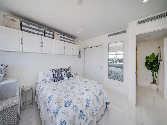 a bedroom with a large bed and a potted plant