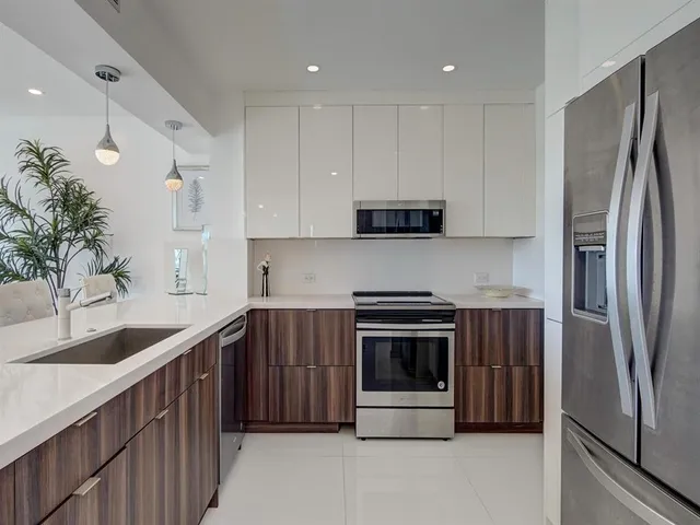 a kitchen with stainless steel appliances granite countertop a refrigerator sink and stove