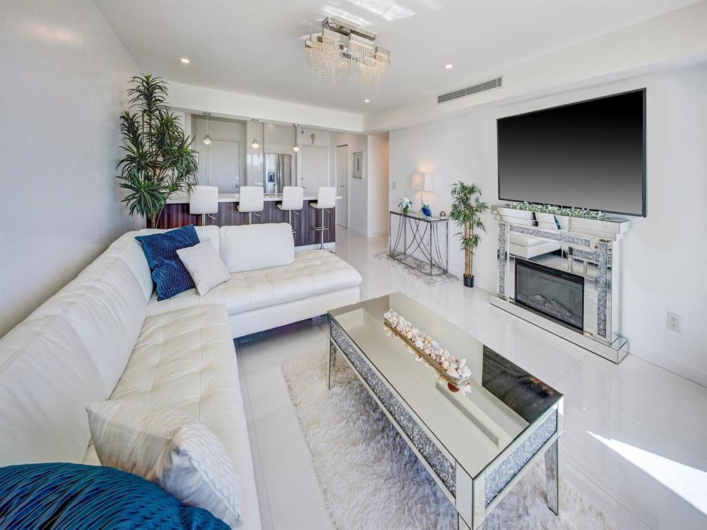 2500 East Las Olas Boulevard, Unit 707 Fort Lauderdale, FL 33301 - Photo 7 of 29 a living room with furniture a flat screen tv and a fireplace