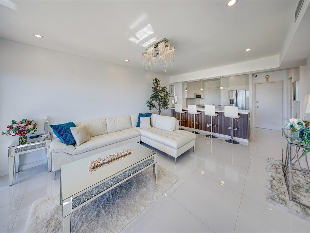 2500 East Las Olas Boulevard, Unit 707 Fort Lauderdale, FL 33301 - Photo 8 of 29 a living room with furniture and a chandelier