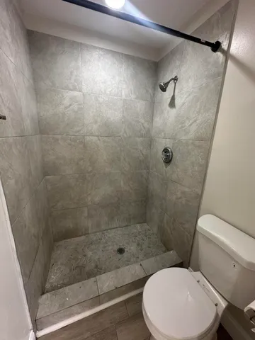 a white toilet sitting next to a bath tub and shower