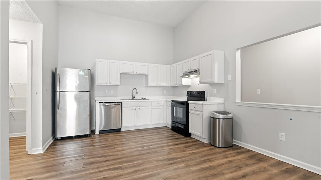 4890 Wilkins Station Drive Decatur, GA 30035 - Photo 15 of 34 a kitchen with a refrigerator cabinets and wooden floor