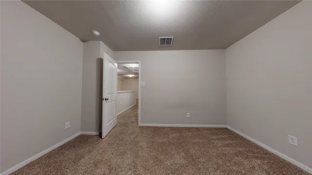 a view of a backyard with large trees and a wooden fence