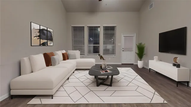 a view of a big room with wooden floor and windows