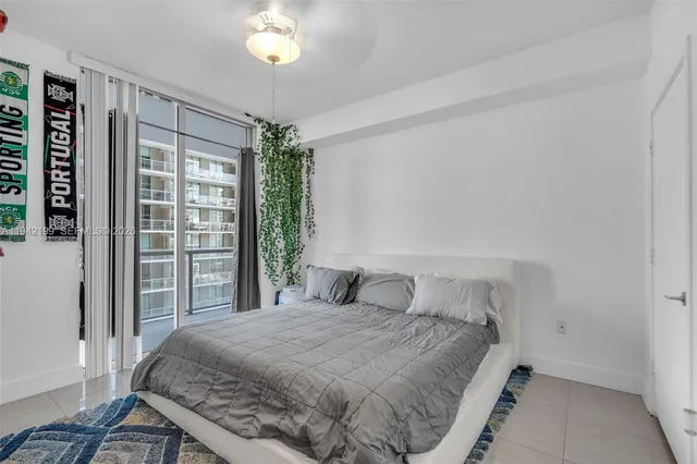 a bedroom with a large bed and a chandelier