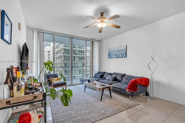 a living room with furniture a chandelier and a flat screen tv