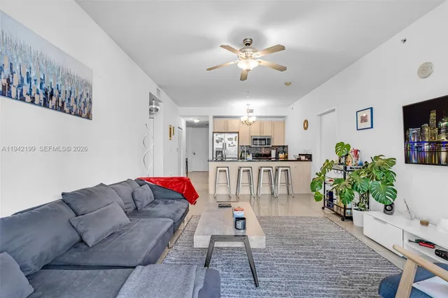 a living room with furniture kitchen and a chandelier