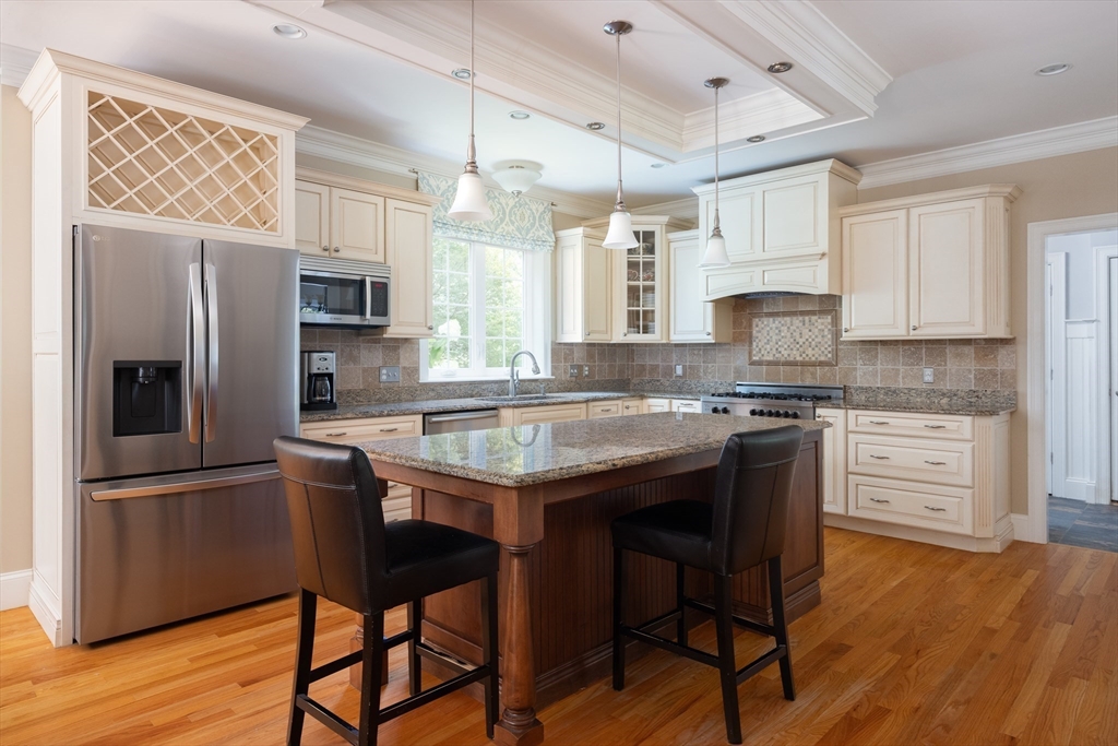 5 Peachtree Road Lexington, MA 02420 - Photo 3 of 18 a kitchen with kitchen island granite countertop a sink cabinets and wooden floor