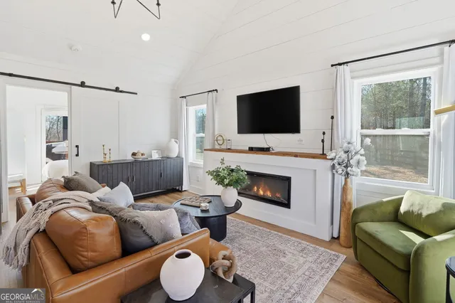 a living room with furniture a fireplace and a flat screen tv