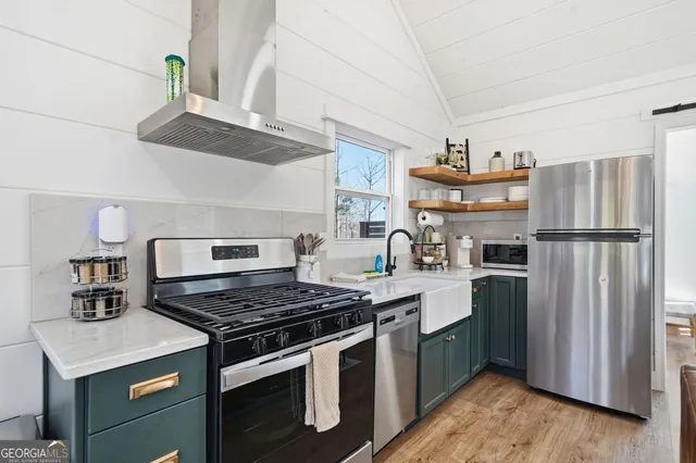 a kitchen with stainless steel appliances granite countertop a stove a refrigerator and a sink