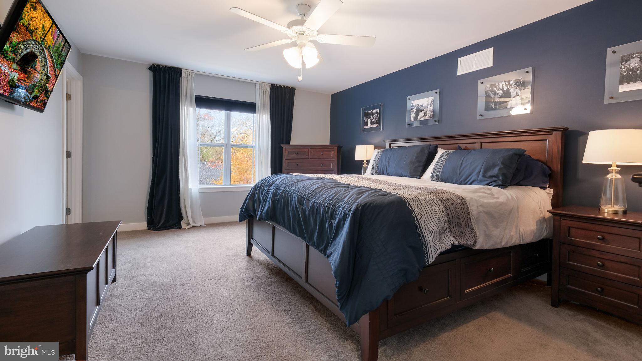 42 Independence Court Perkasie, PA 18944 - Photo 16 of 23 a spacious bedroom with a bed and a chandelier