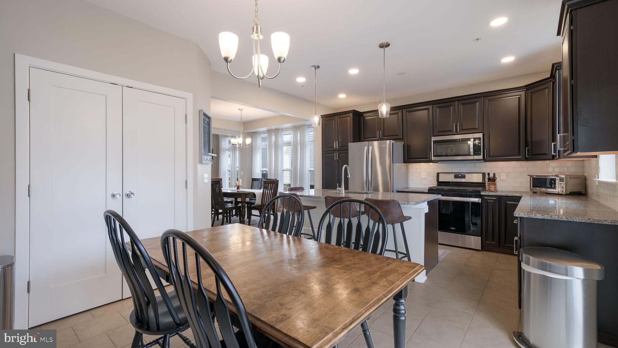 42 Independence Court Perkasie, PA 18944 - Photo 7 of 23 a kitchen with stainless steel appliances granite countertop a stove a refrigerator a kitchen island a dining table and chairs