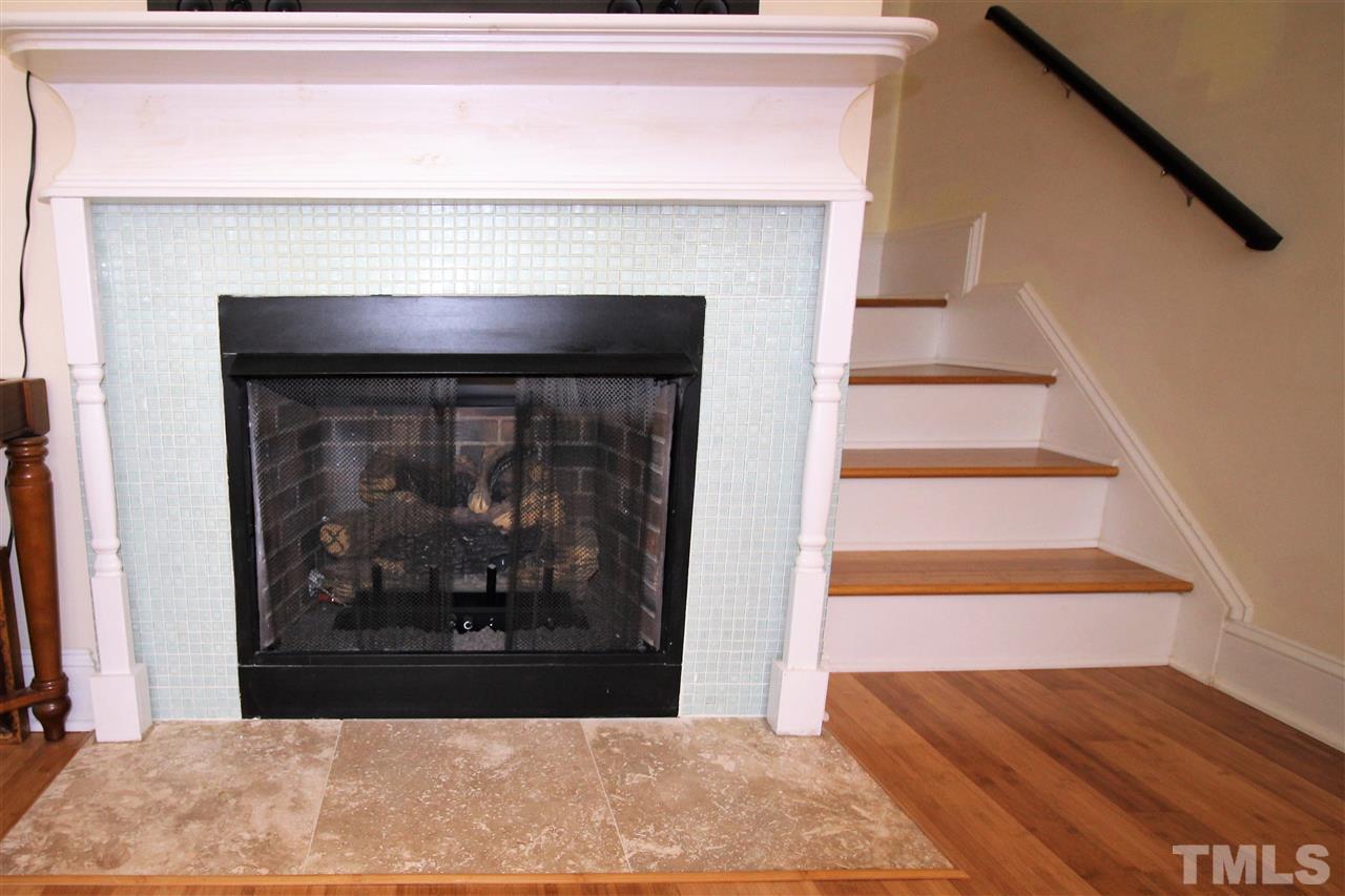2514 Noble Road Raleigh, NC 27608 - Photo 8 of 16 a view of a livingroom with wooden floor and a fireplace