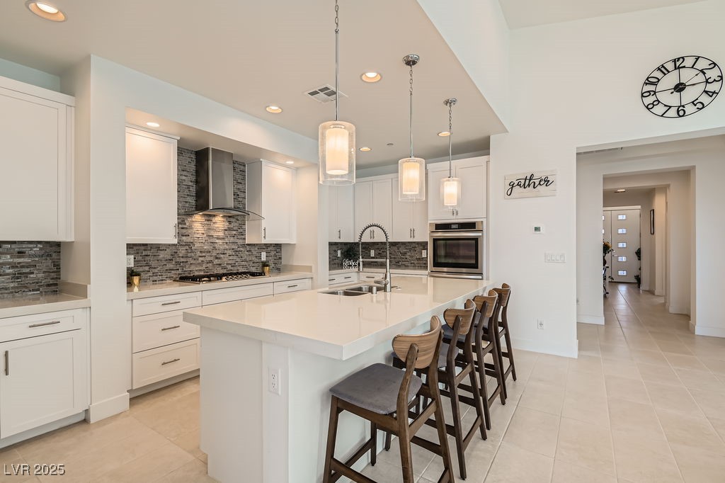 130 West Fairway Road Henderson, NV 89015 - Photo 11 of 40 Kitchen featuring light tile patterned floors, a center island with sink, hanging light fixtures, a kitchen breakfast bar, and recessed lighting