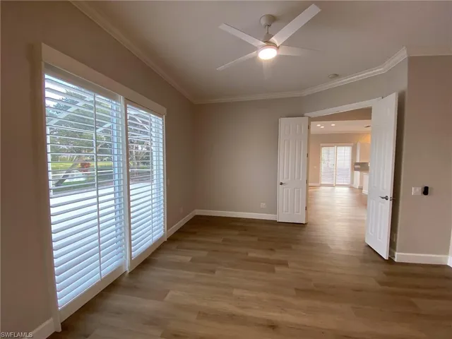 a living room with stainless steel appliances kitchen island hardwood floor and a ceiling fan
