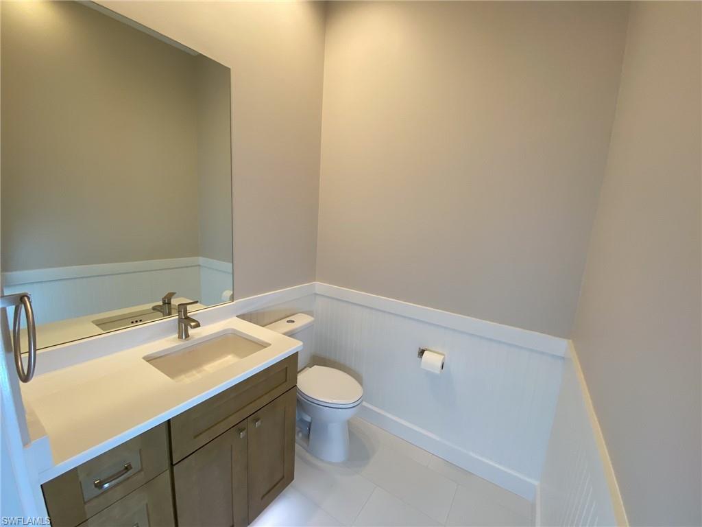 2740 Island Pond Lane Naples, FL 34119 - Photo 13 of 43 a bathroom with a sink a toilet and a mirror