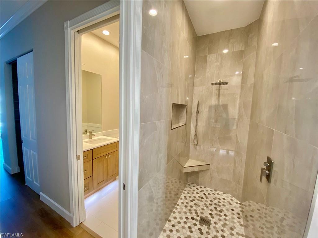2740 Island Pond Lane Naples, FL 34119 - Photo 14 of 43 a bathroom with a granite countertop shower a toilet and a sink