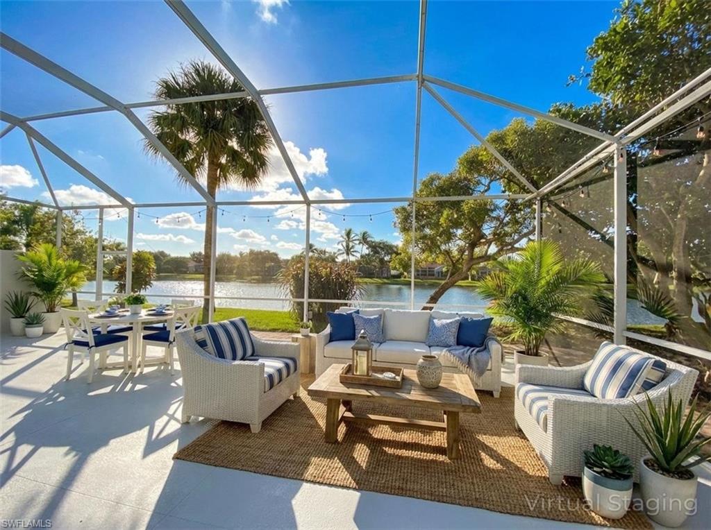 2740 Island Pond Lane Naples, FL 34119 - Photo 29 of 43 a patio with patio a table and chairs under an umbrella