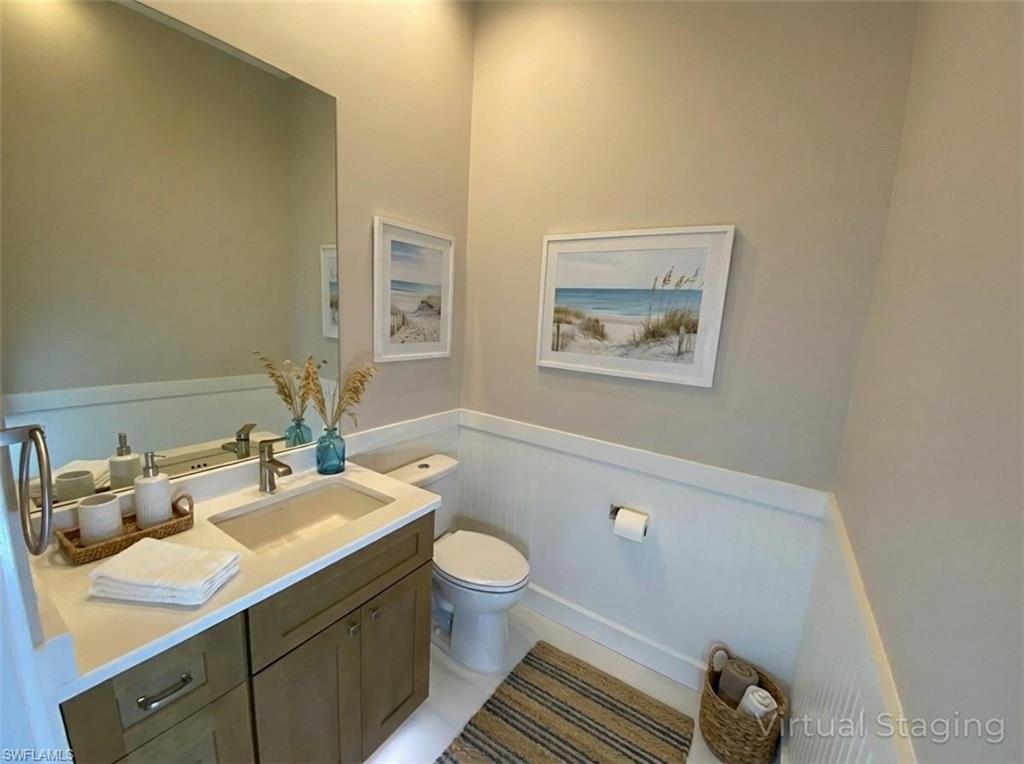 2740 Island Pond Lane Naples, FL 34119 - Photo 37 of 43 a bathroom with a sink mirror vanity and toilet