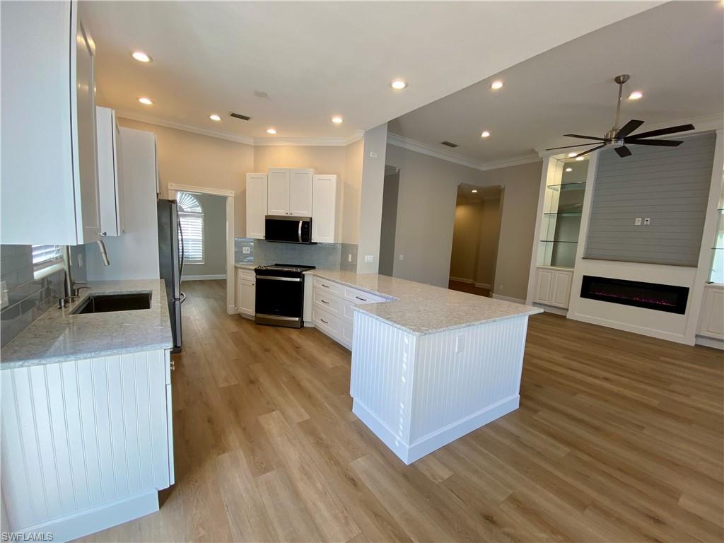 2740 Island Pond Lane Naples, FL 34119 - Photo 41 of 43 a living room with stainless steel appliances furniture a refrigerator and a kitchen view