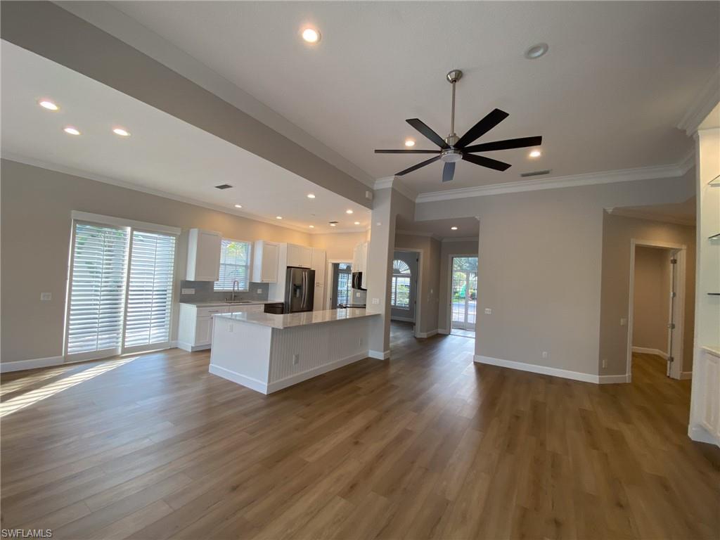 2740 Island Pond Lane Naples, FL 34119 - Photo 43 of 43 a living room with stainless steel appliances kitchen island hardwood floor and a ceiling fan