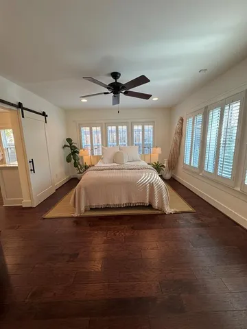 a bedroom with a bed and a ceiling fan