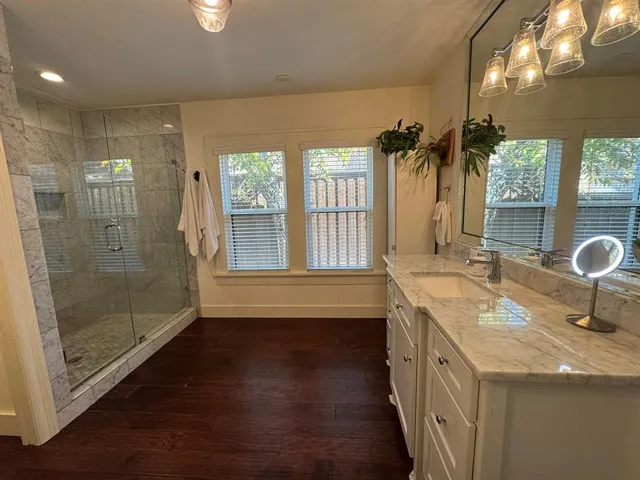 a bathroom with a granite countertop sink a large mirror and shower