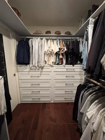 a view of walk in closet with clothes and shoes