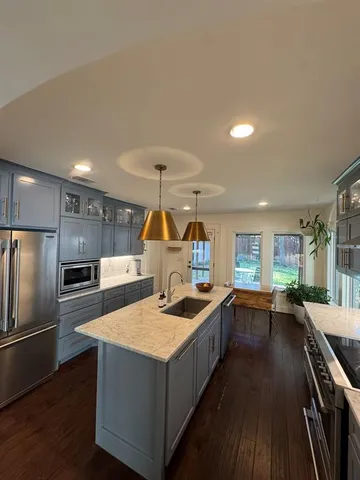 a kitchen with stainless steel appliances granite countertop a sink a stove and a refrigerator