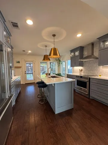 a kitchen with stainless steel appliances granite countertop a lot of counter space and wooden floors