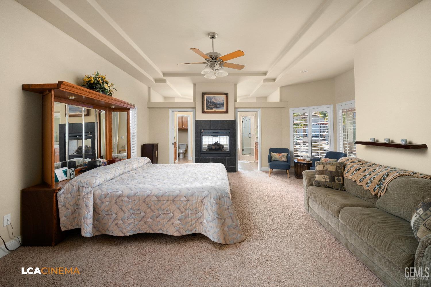 Undisclosed Address Bakersfield, CA 93314 - Photo 39 of 71 a spacious bedroom with a bed couch chandelier and a fireplace