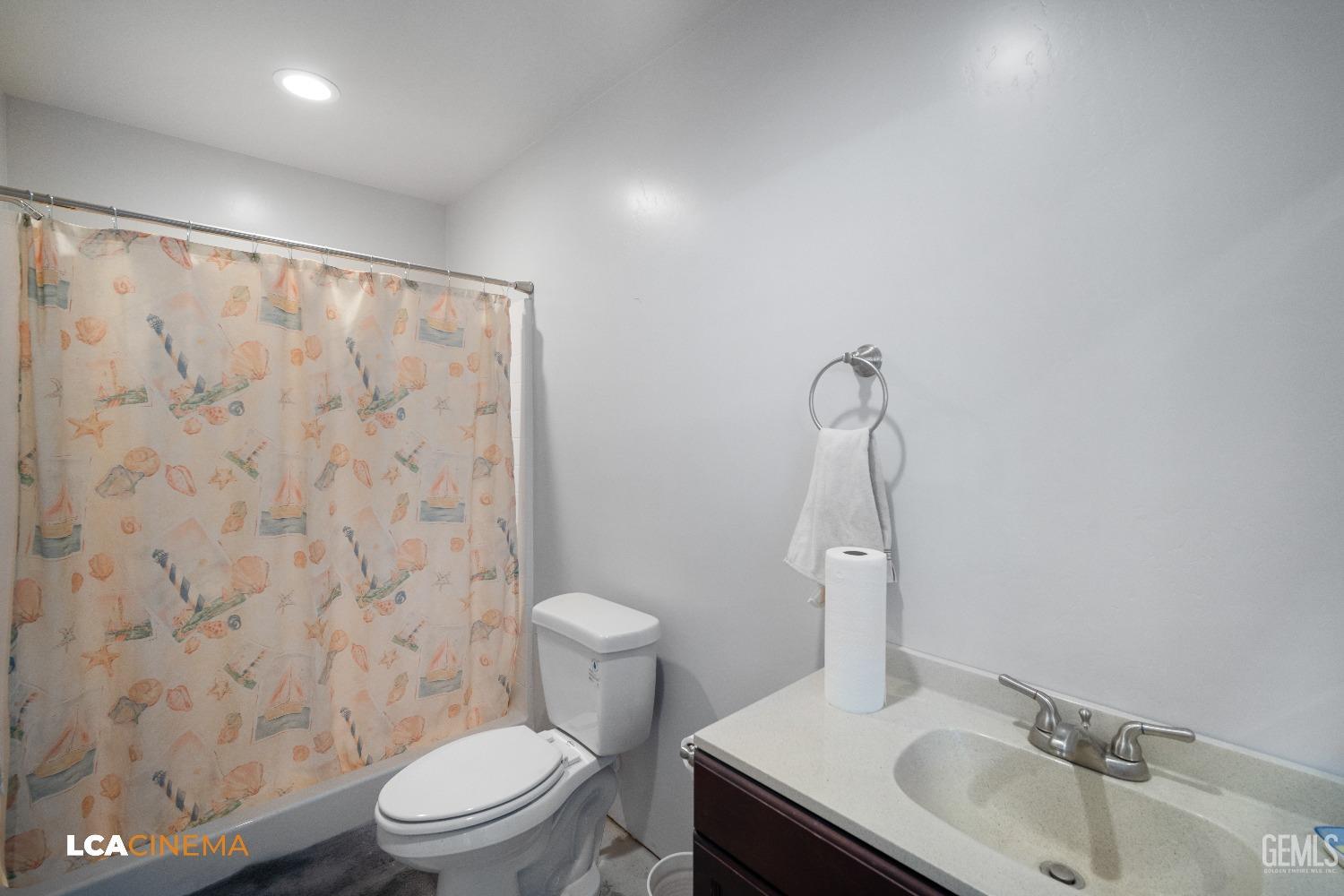Undisclosed Address Bakersfield, CA 93314 - Photo 67 of 71 a bathroom with a sink a toilet and shower curtain