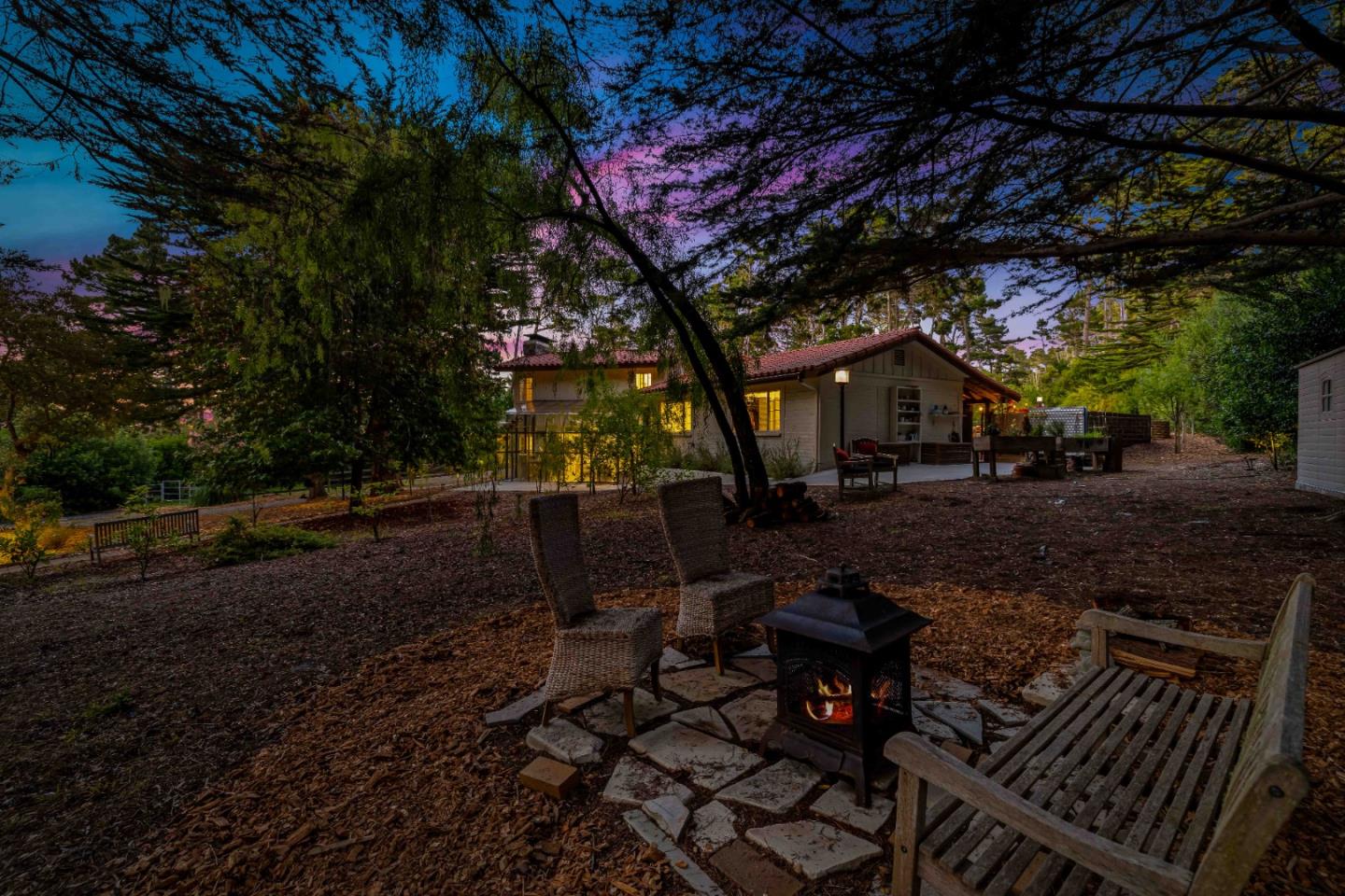 1268 Viscaino Road Pebble Beach, CA 93953 - Photo 33 of 47 a view of a backyard with table and chairs with wooden fence and plants