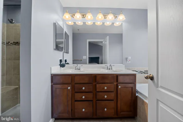 a bathroom with a double vanity and a mirror