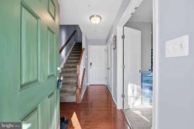 a view of a hallway with wooden floor and entryway