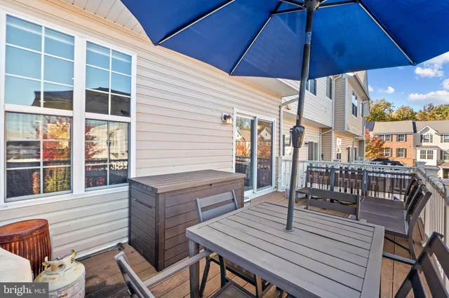 a view of a roof deck with table and chairs under an umbrella