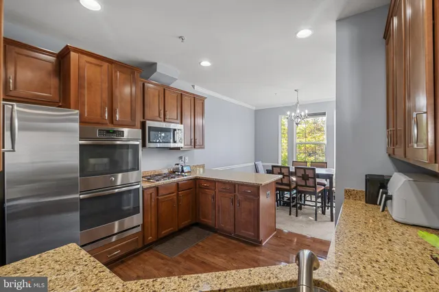 a kitchen with stainless steel appliances granite countertop a sink stove and cabinets