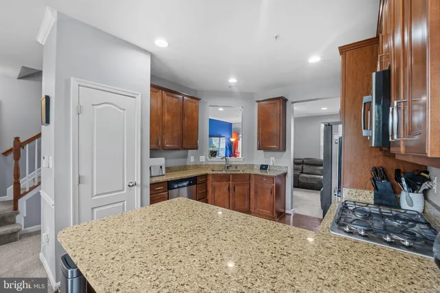 a kitchen with stainless steel appliances granite countertop sink stove refrigerator and cabinets