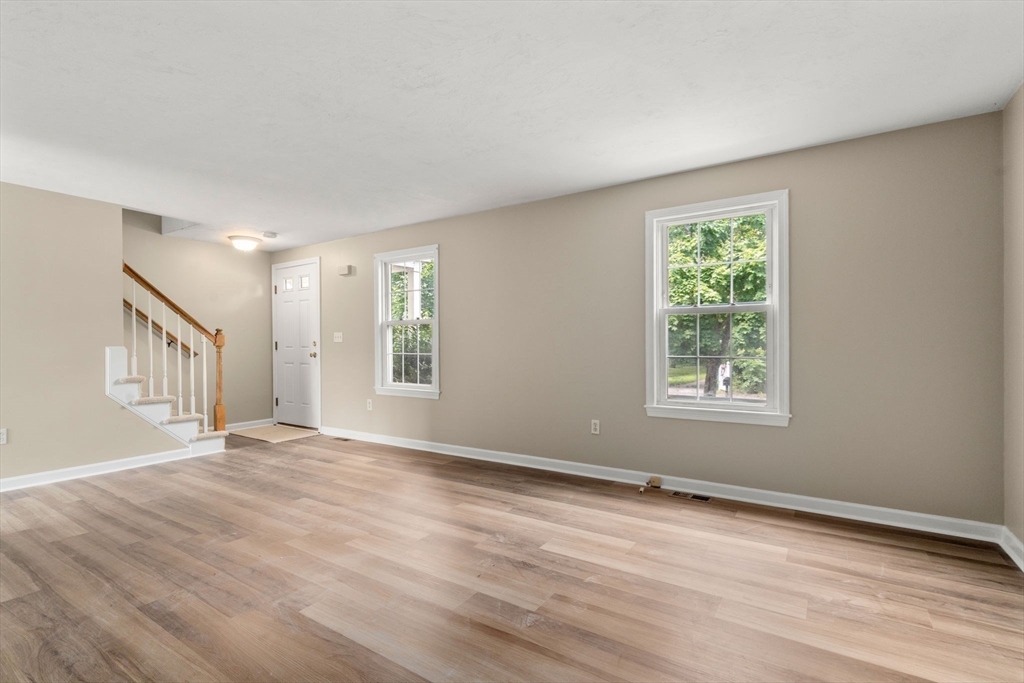 33 Fuller Avenue, Unit 33 Attleboro, MA 02703 - Photo 7 of 16 a view of an empty room with wooden floor and a window