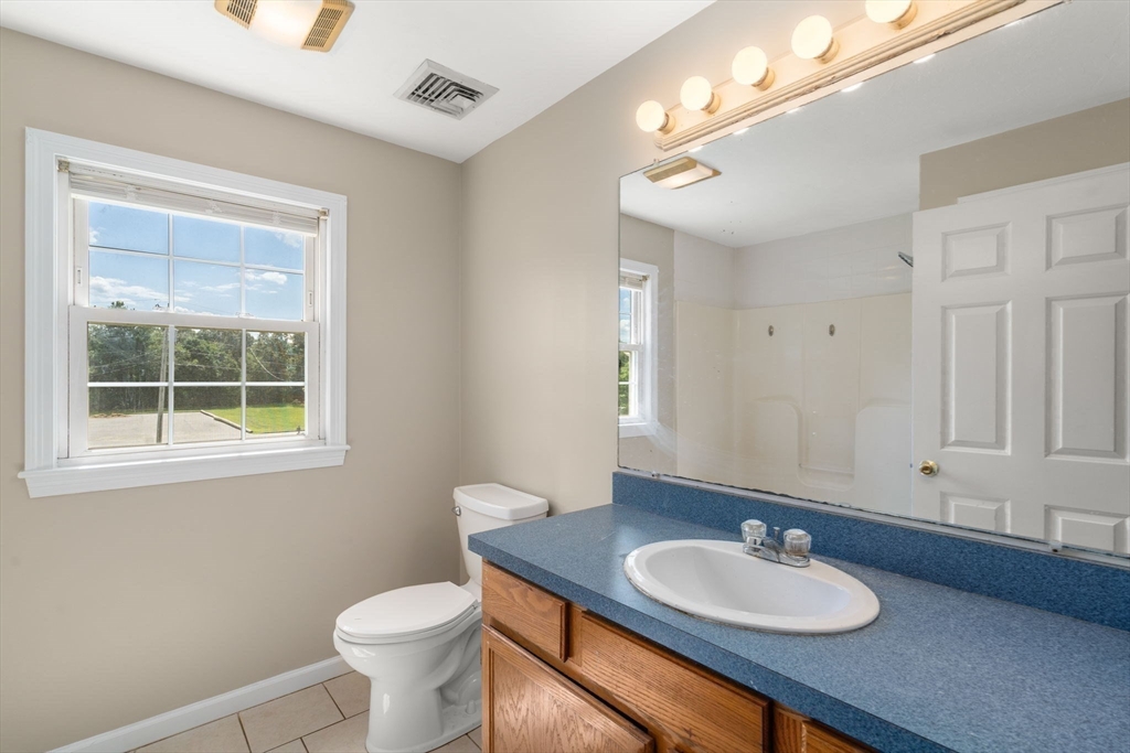 33 Fuller Avenue, Unit 33 Attleboro, MA 02703 - Photo 8 of 16 a bathroom with a toilet sink and mirror