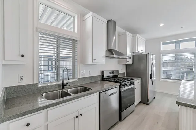 a kitchen with stainless steel appliances granite countertop a sink stove and refrigerator