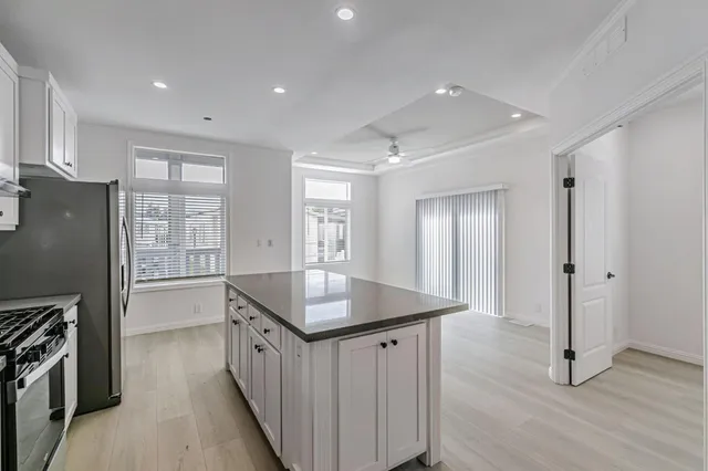 a kitchen with stainless steel appliances granite countertop a refrigerator a stove and a sink