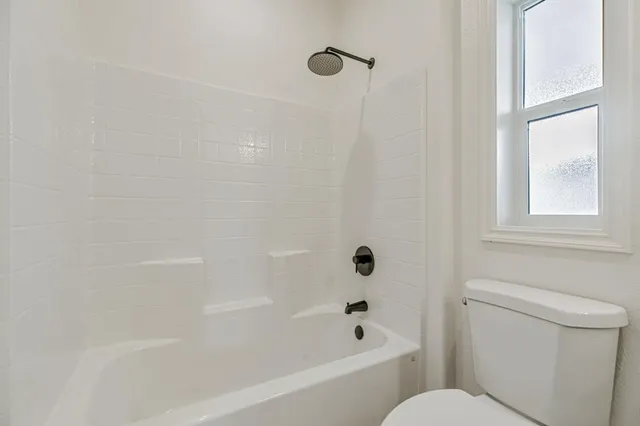 a bathroom with a granite countertop toilet sink and mirror