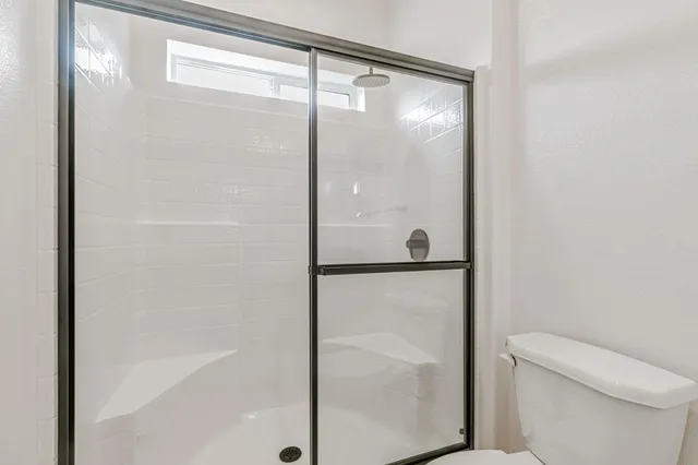 a bathroom with a granite countertop sink a toilet and shower