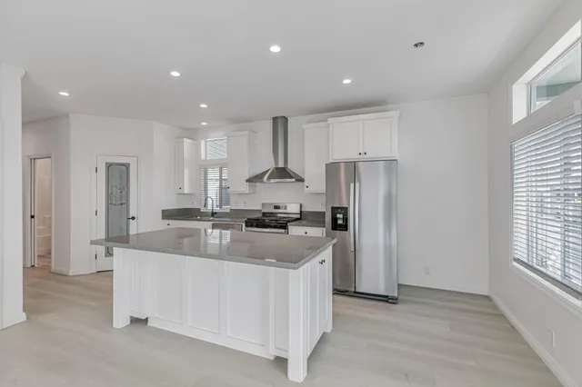 a kitchen with kitchen island a sink stove and refrigerator