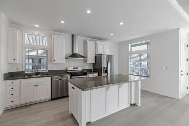 a kitchen with stainless steel appliances granite countertop a sink stove and refrigerator