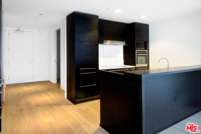 a kitchen with kitchen island sink and refrigerator