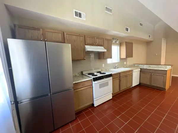 a kitchen with stainless steel appliances a refrigerator sink and white cabinets