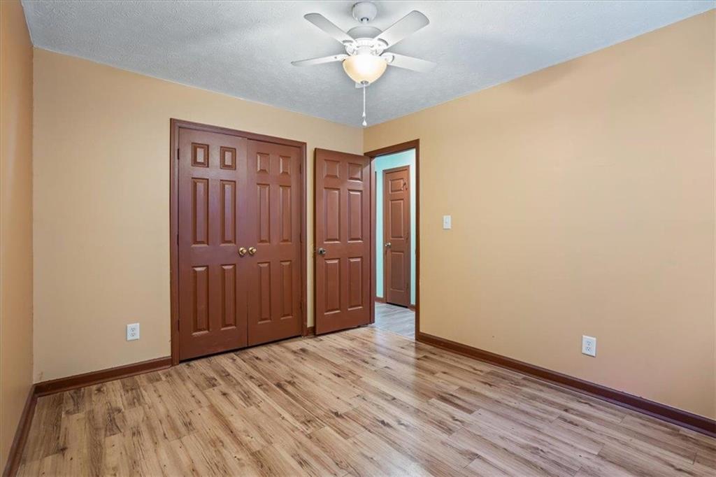 150 Crystal Brook Griffin, GA 30223 - Photo 13 of 28 a view of a hallway with a chandelier fan and wooden floor