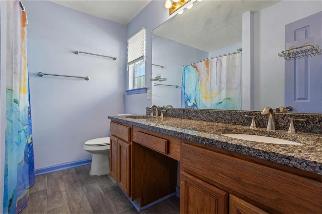 150 Crystal Brook Griffin, GA 30223 - Photo 19 of 28 a bathroom with a granite countertop sink a toilet and a mirror